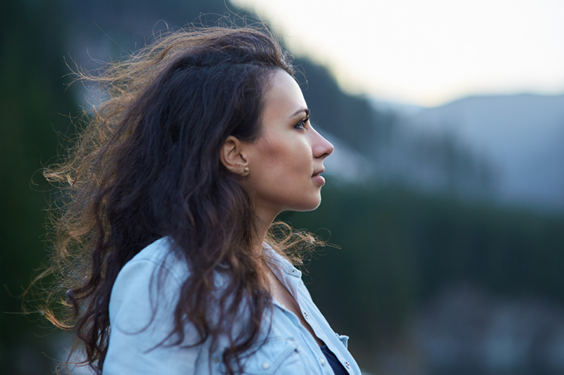 Woman with hands crossed over chest in peace and relief.